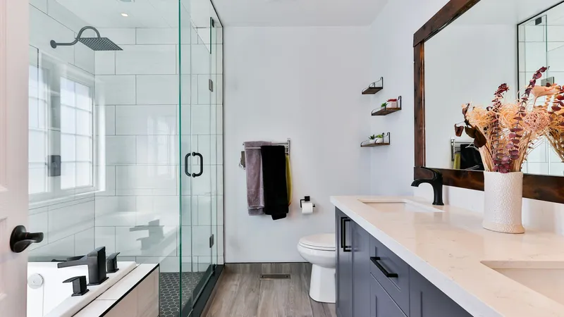 Remodeled bathroom with a frameless glass tile shower and a double vanity