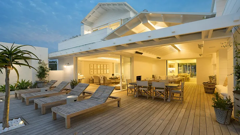 Wood deck with lounge seating at a white coastal Florida home