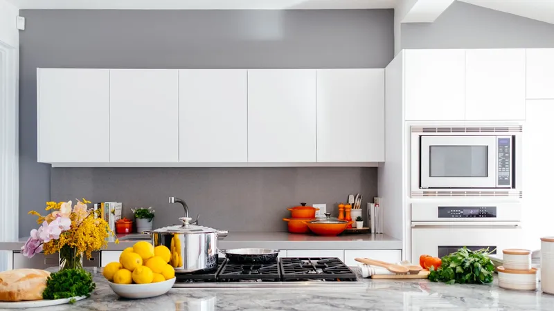 Bright remodeled kitchen with white cabinets, gray quartz counters, and a gas cooktop
