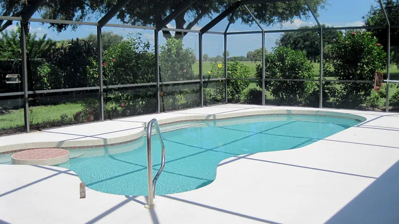Screened lanai pool enclosure at a Florida home on a sunny day